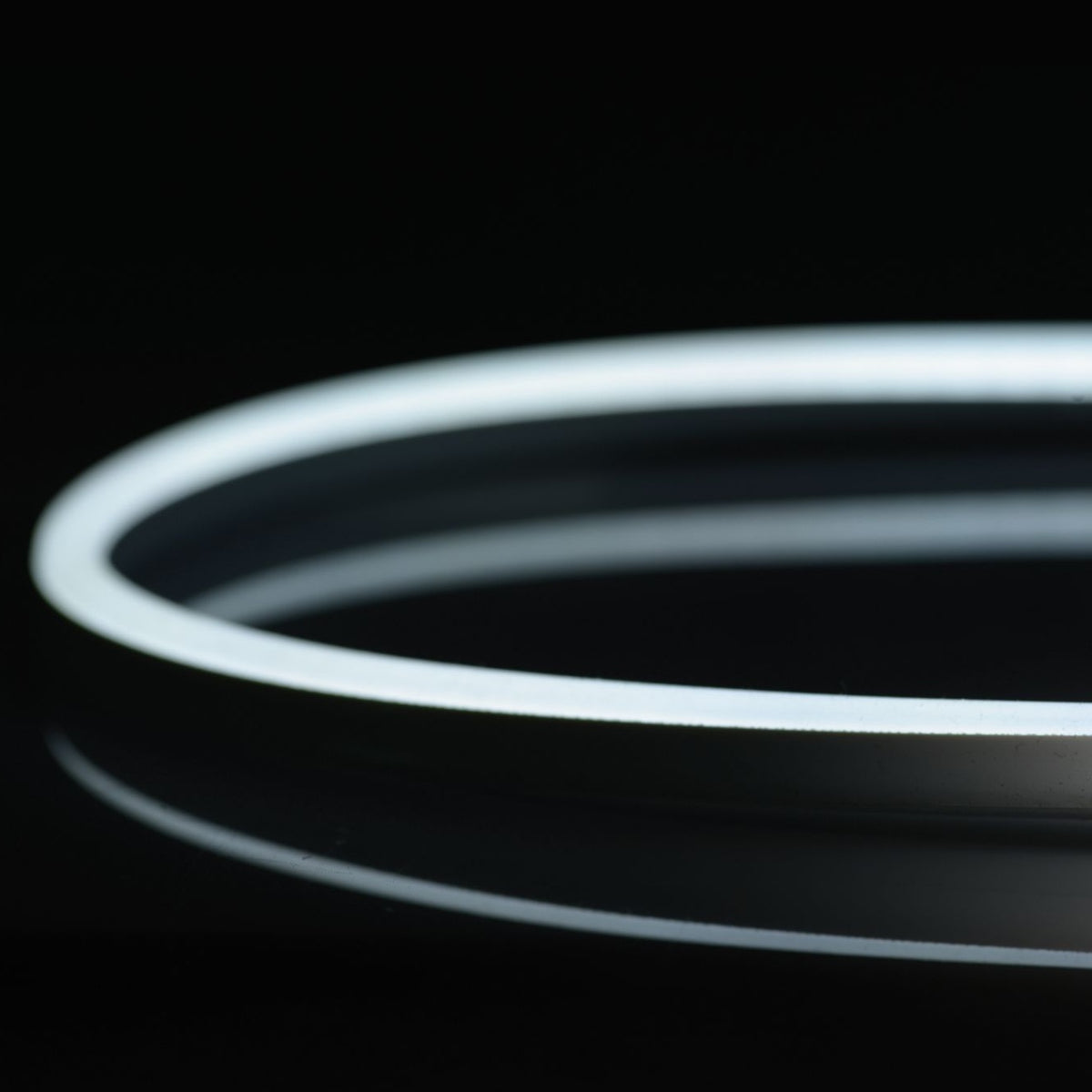 N914-NW-10 QolorFLEX NuNeon natural white LED tape coiled and illuminated on black, showing continuous dot-free glow, City Theatrical