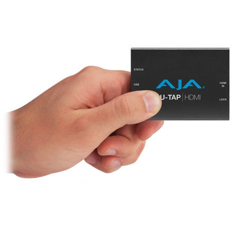 AJA U-TAP HDMI held in a hand to show the pocket-size capture device scale