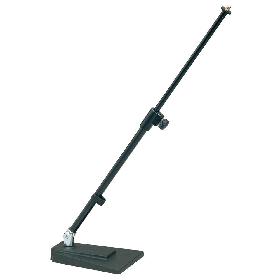 KM 23400.500.55 low-profile microphone stand angled full view showing cast wedge base, chrome tilt joint and telescoping black boom with knurled height clamp, K&M