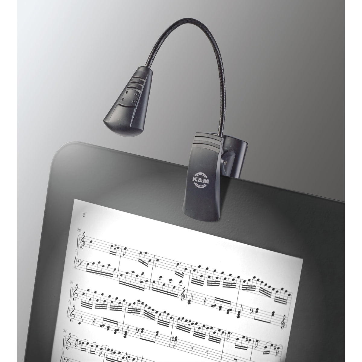 12241 LED FlexLight clipped to a music folder, K&M logo on clip and lamp lighting a printed score, K&M