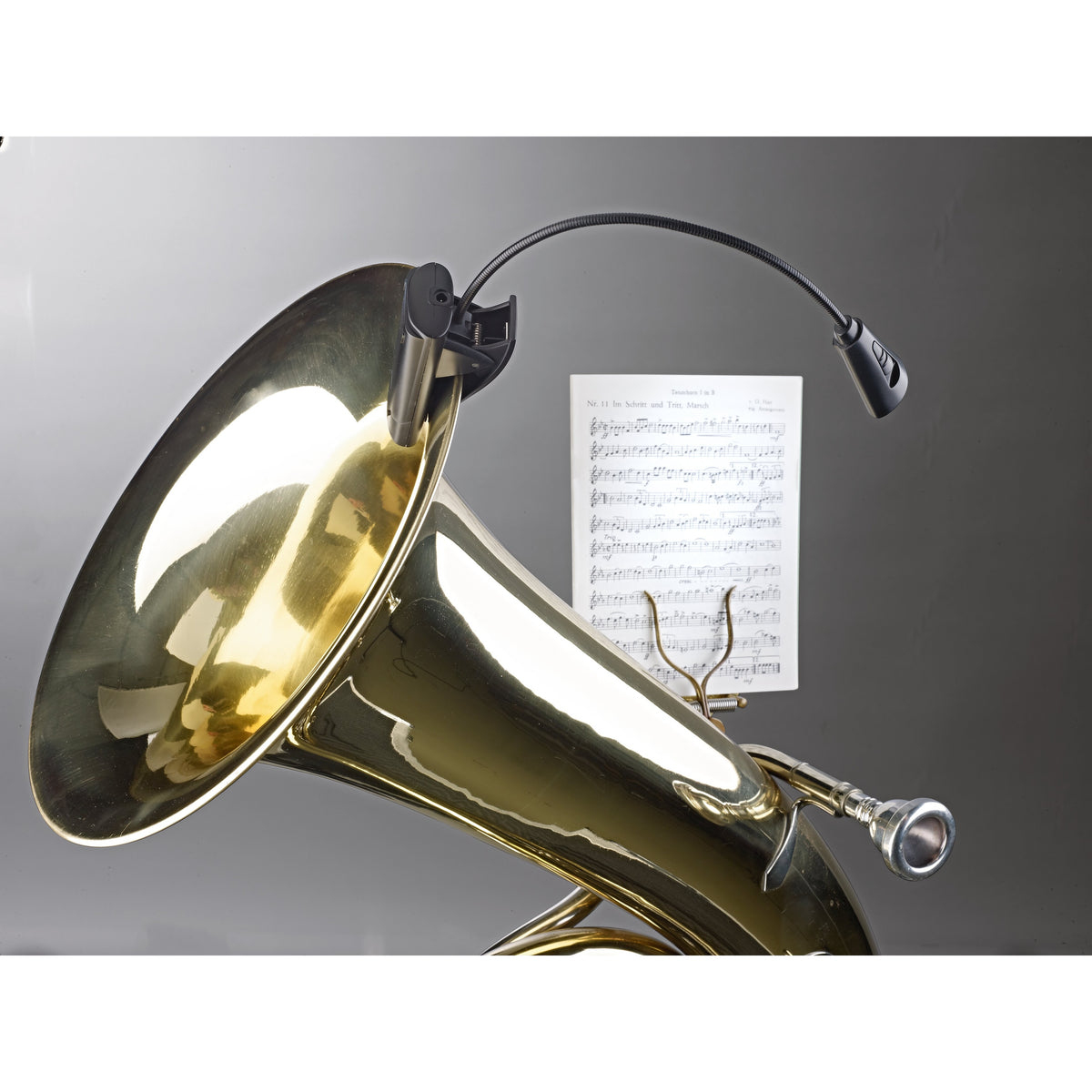 12242 LED flex light clamped to the bell of a brass horn with the gooseneck extended over a sheet of music on a lyre, K&M