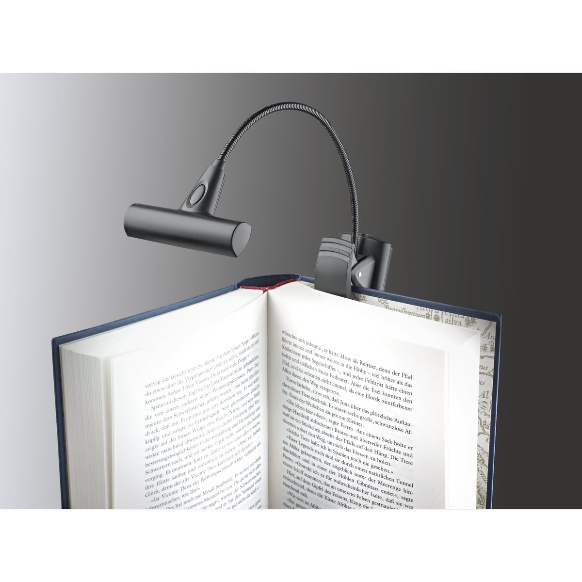 12247 LED FlexLight T-Model clipped to the cover of an open book, flexible gooseneck with switch on the lamp head, K&M