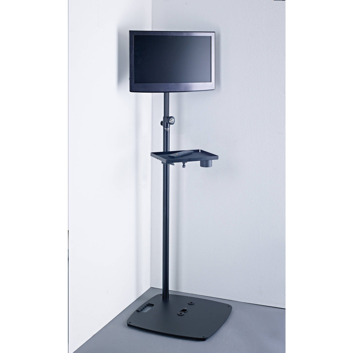 KM 26706.000.56 base plate supporting a flat-panel monitor stand with accessory shelf in a corner setup, K&M