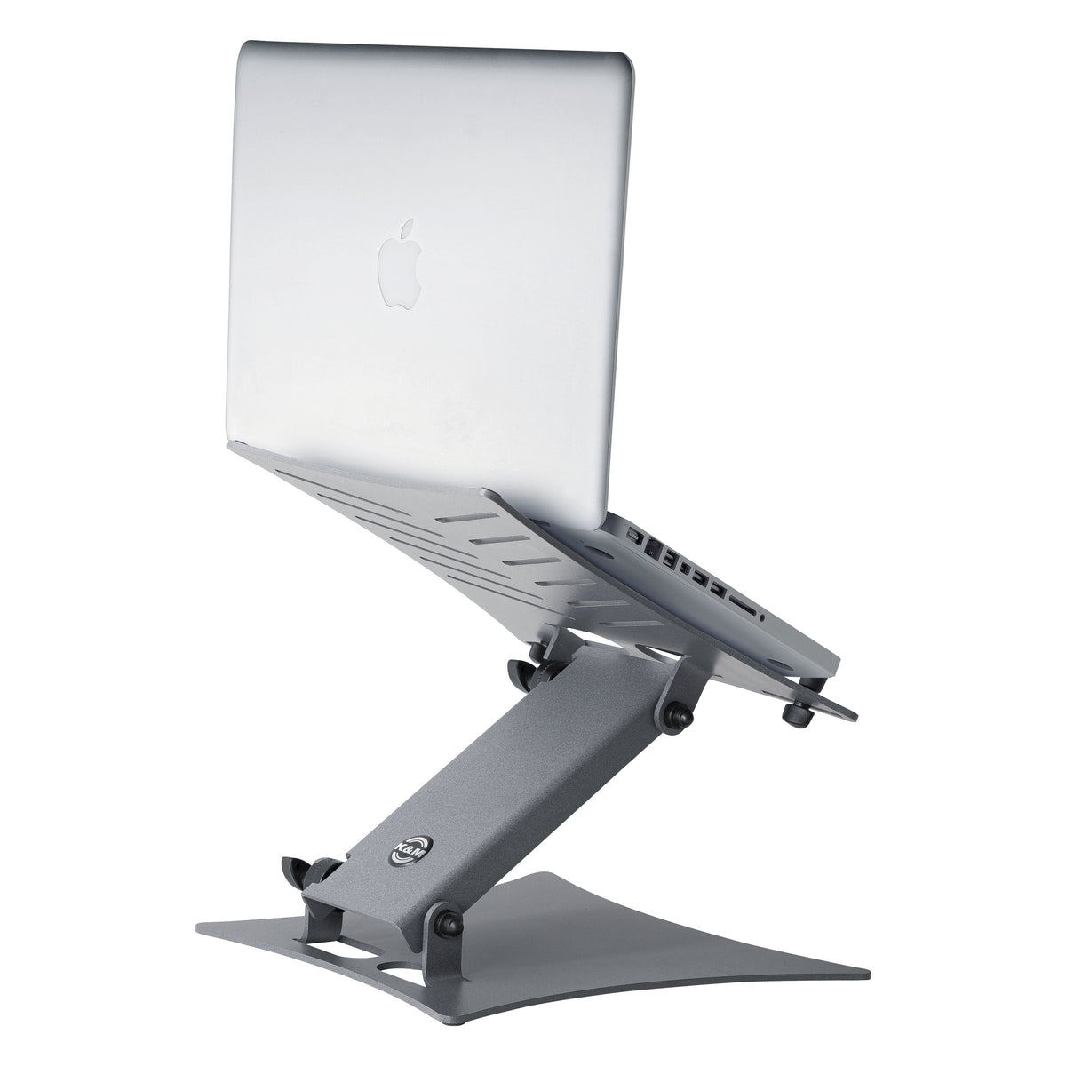 12195 laptop stand in use with a MacBook raised on the angled platform and K&M logo on the support arm, K&M