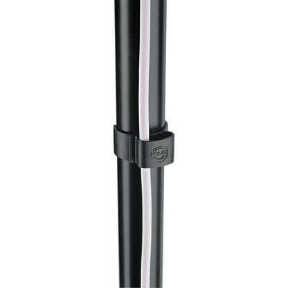21406 cable clamp in use on black stand tube holding a white cable against the pole, close-up with embossed K&M logo, K&M