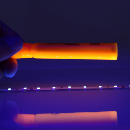QolorFLEX UV LED tape in use, orange highlighter fluorescing above the lit 395nm strip, City Theatrical