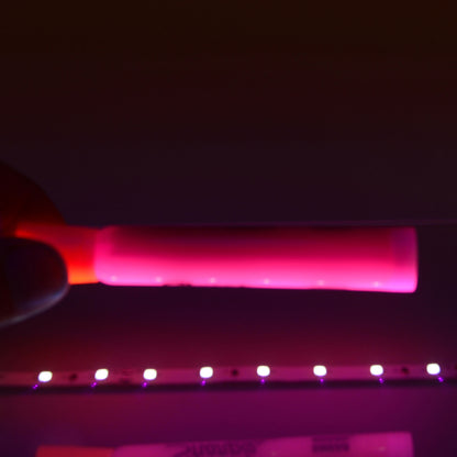 QolorFLEX UV LED tape demo with pink highlighter glowing under 395nm blacklight output, City Theatrical
