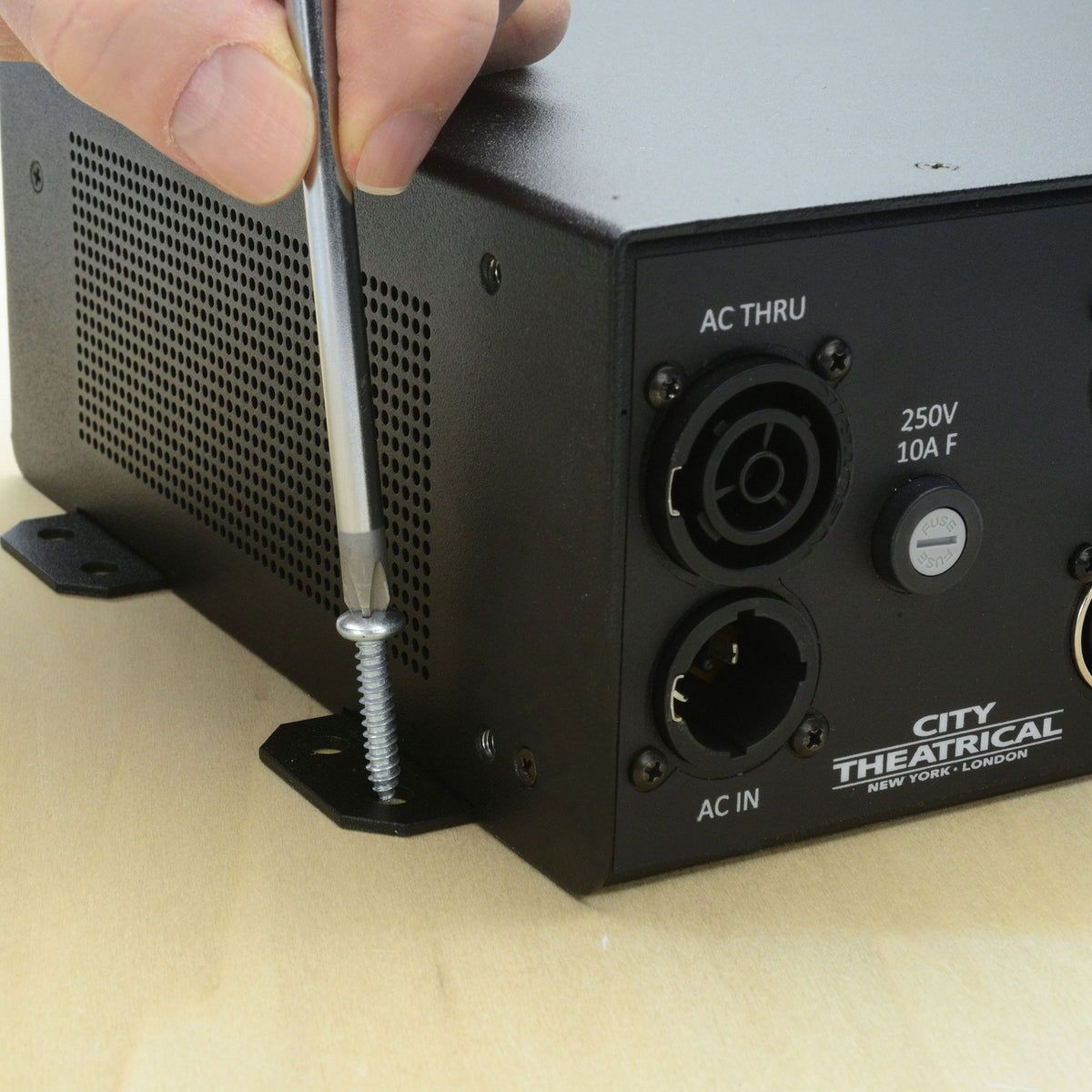 QolorPIX 5850 Tape Controller being screw-mounted to a wood surface through side bracket, next to AC In and fuse, City Theatrical