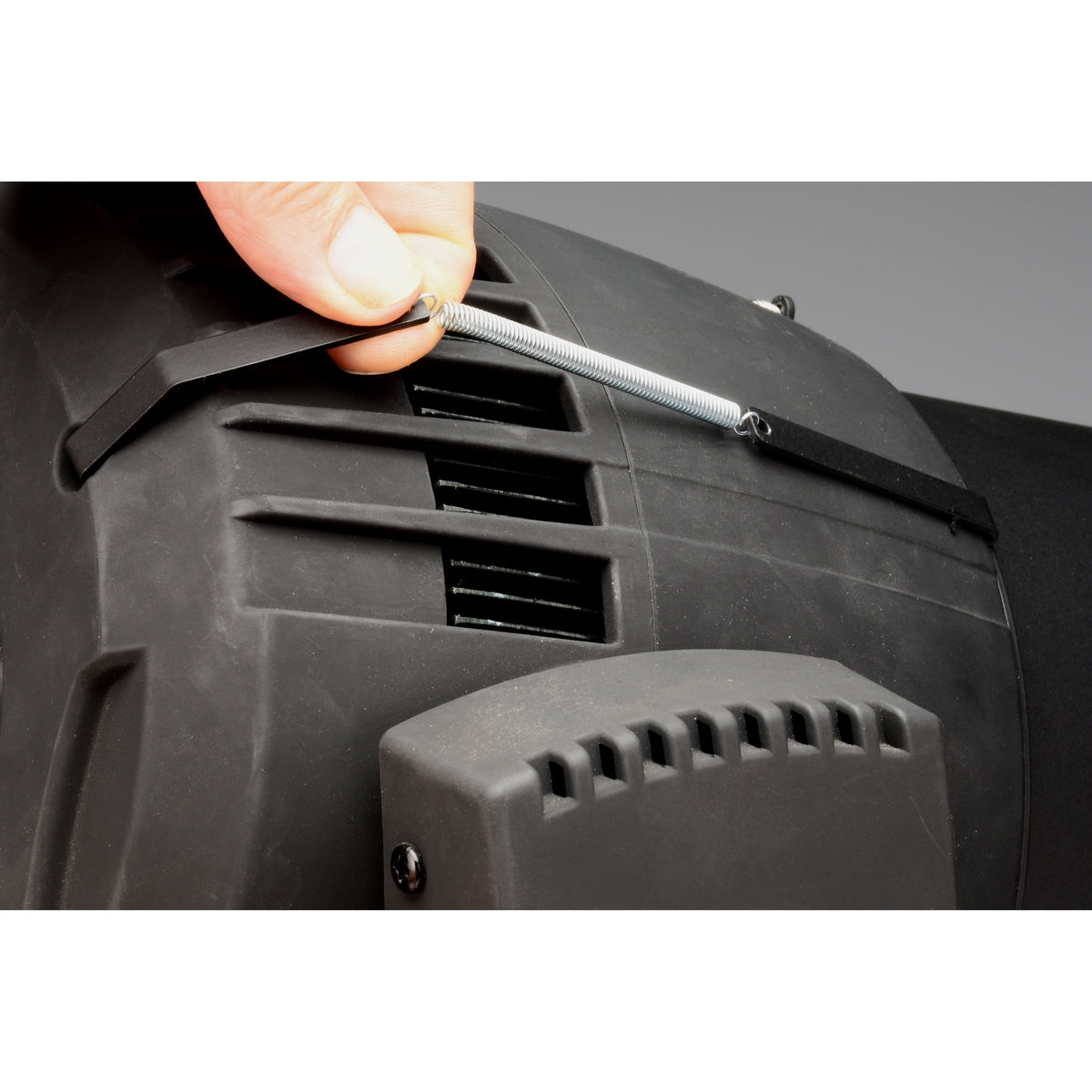 CITTHE 2670 installation detail with hand stretching a tension spring to seat the clip on the fixture housing, City Theatrical