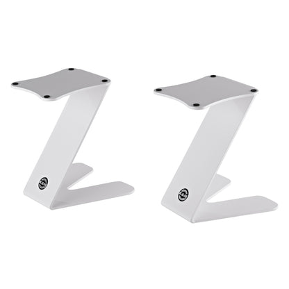 26773 Z-shaped table monitor stand pair in pure white, front three-quarter view showing flat top plates with four black rubber pads and K&M logo badge on the base, K&M