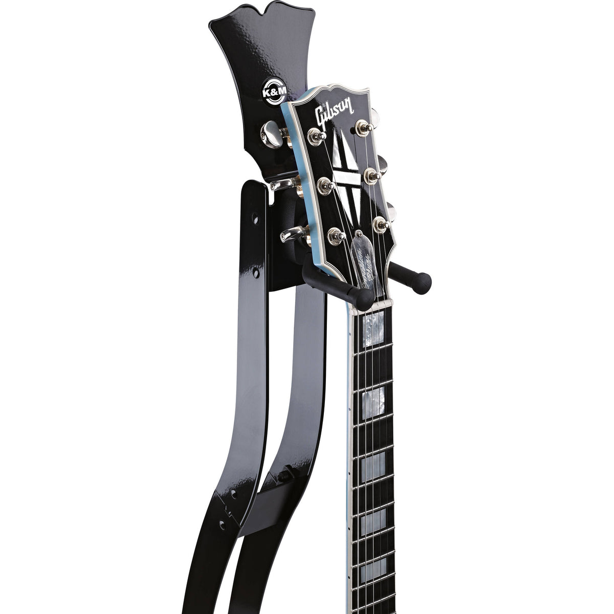 Guitar Station slim metal stand headstock detail, headstock-shaped top plate with K&M logo and padded rubber neck cradle supporting a Gibson headstock, K&M