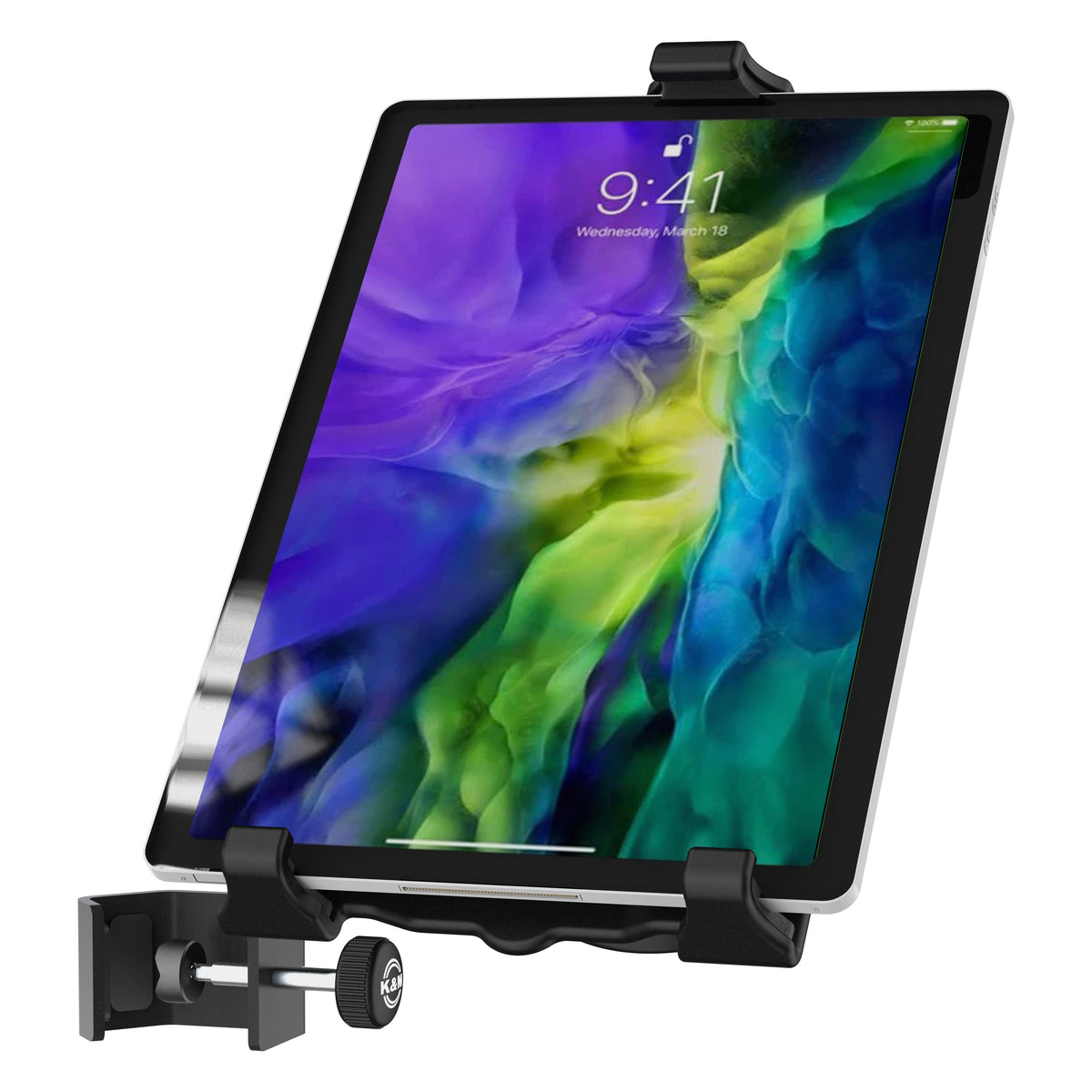 Biobased tablet holder in use gripping a tablet showing a lock screen, with table clamp and thumbscrew at lower left, K&M