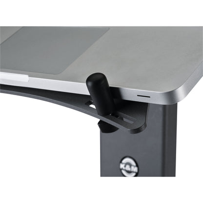 12189 XL stop pin installed in slot of laptop stand shelf holding the edge of a silver laptop, K&M logo visible on stand column, K&M