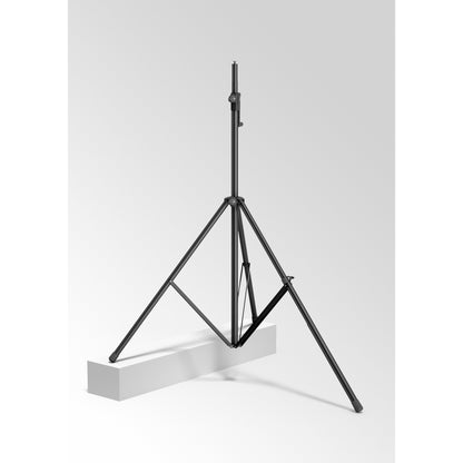 24618 leveling leg in use, one tripod leg of a black speaker and lighting stand resting on a raised white block to level the stand on uneven ground, K&M