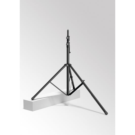24738 leveling leg in use on a wind-up speaker stand with one tripod leg extended to rest on a raised white block for uneven ground, K&M