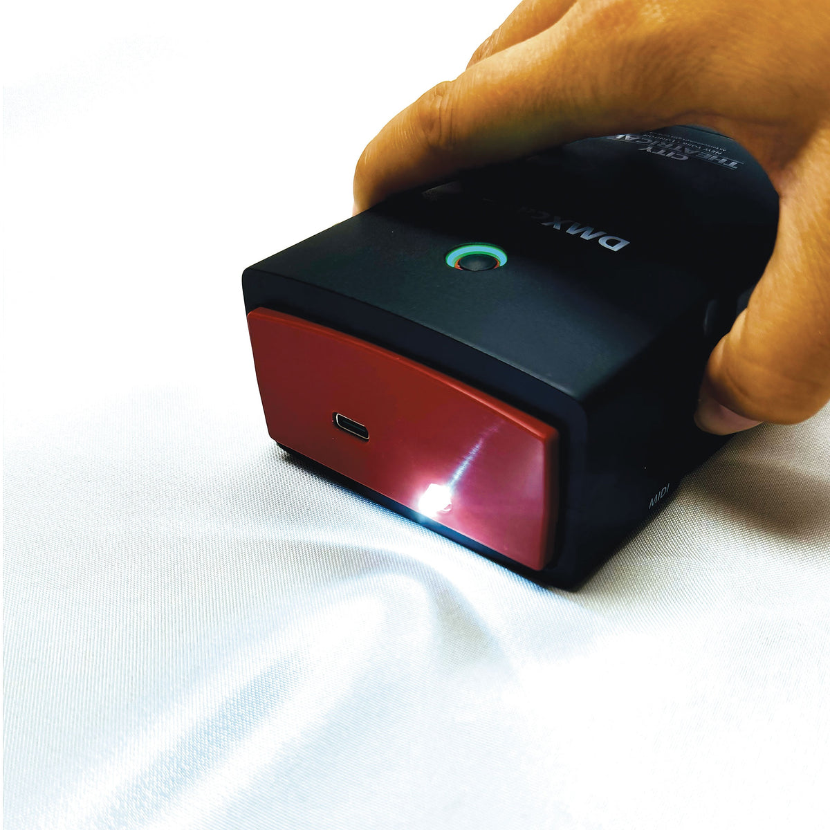 DMXcat-E 6100 top-down angle with built-in work light beam projected onto surface, City Theatrical