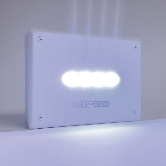AtlasIED IP-F wall mount alert endpoint with LED bar illuminated white against a gray surface