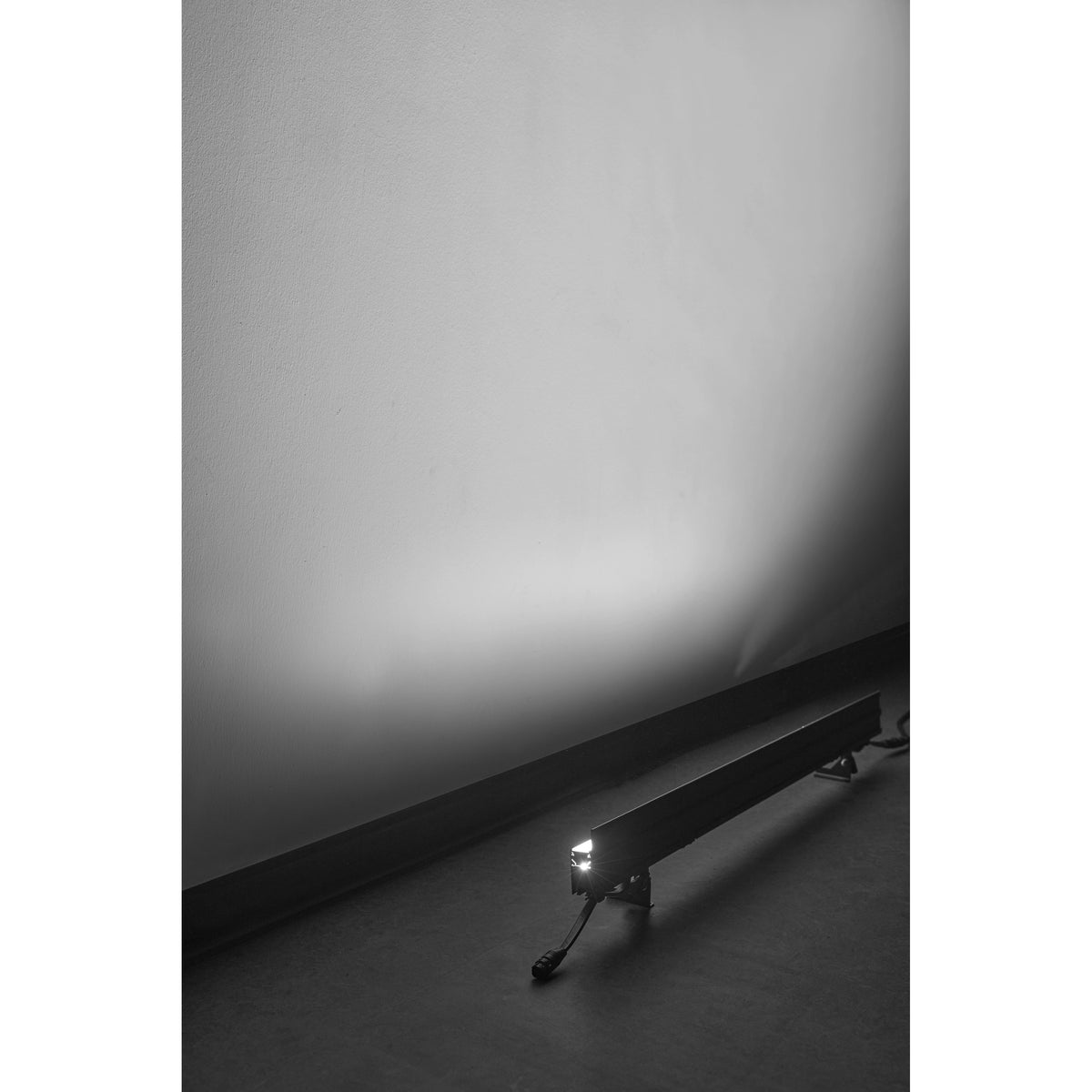 VDO Sceptron XB angled on floor stand grazing a wall with white light, Martin Lighting