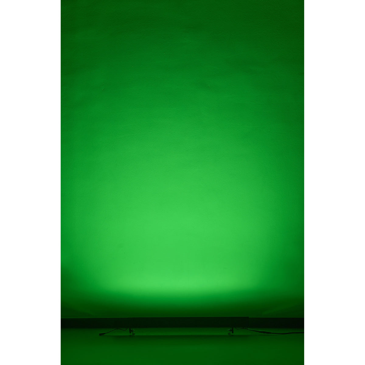 VDO Sceptron XB washing a wall in green from a floor-mounted position, Martin Lighting