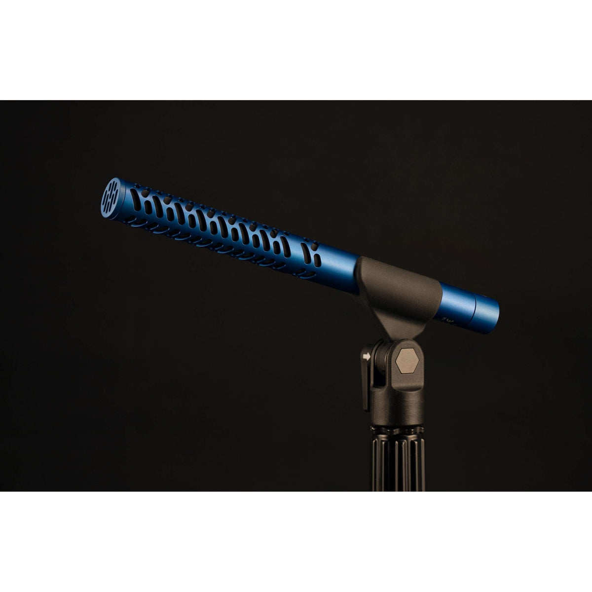 S1 supercardioid shotgun mic side view in blue anodized finish with slotted interference tube, mounted in a black stand clip on a dark background, Lectrosonics