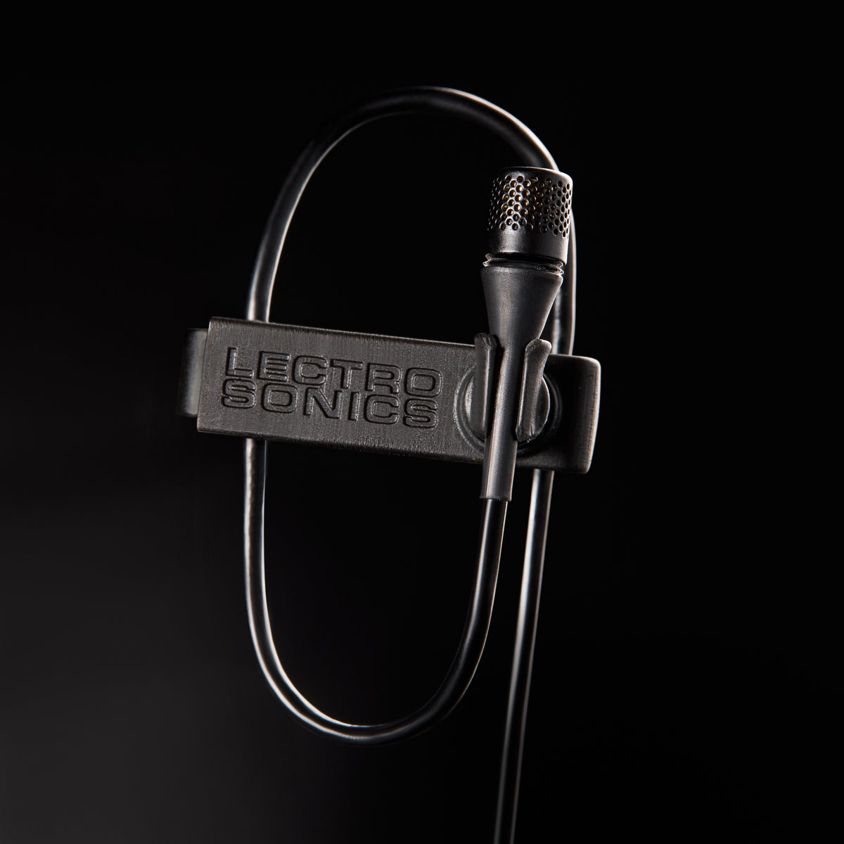 L1 Sonaura lavalier macro detail of perforated capsule grille and branded mic clip with cable loop, Lectrosonics