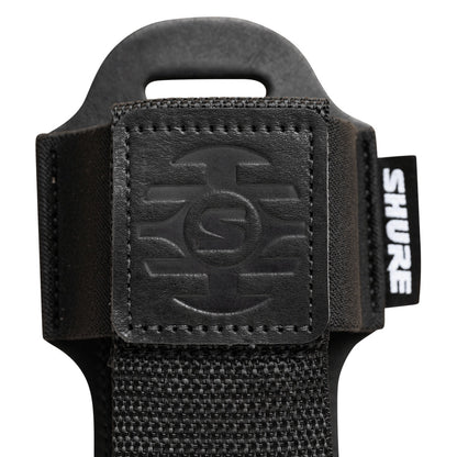 SH-BODYPACK-PBK-L bodypack transmitter pouch close-up of stitched embossed leather logo patch, woven nylon strap and Shure label, Gator