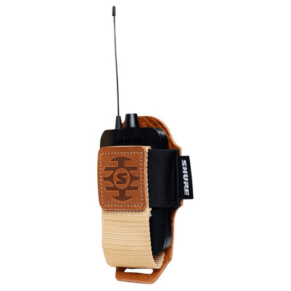 SH-BODYPACK-PTN-L bodypack pouch angled side view with Shure bodypack transmitter secured by elastic band and tan webbing strap, Gator