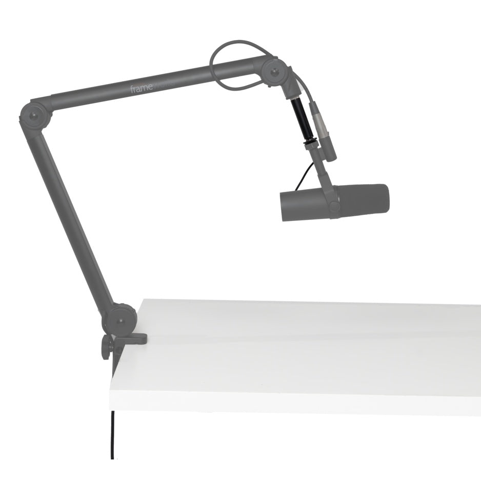 GFWMICBCBMEXT extension adapter fitted on desk-clamped broadcast boom arm holding a microphone, adapter highlighted in black, Gator