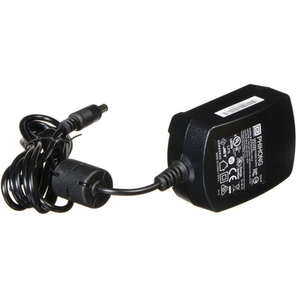 Blackmagic Design Video Assist power supply angled to show spec label, coiled cable, and DC barrel plug