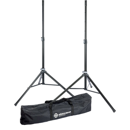 21449 aluminum speaker stand pair full view with two black tripod stands extended beside a black carry case printed with the König & Meyer logo, K&M