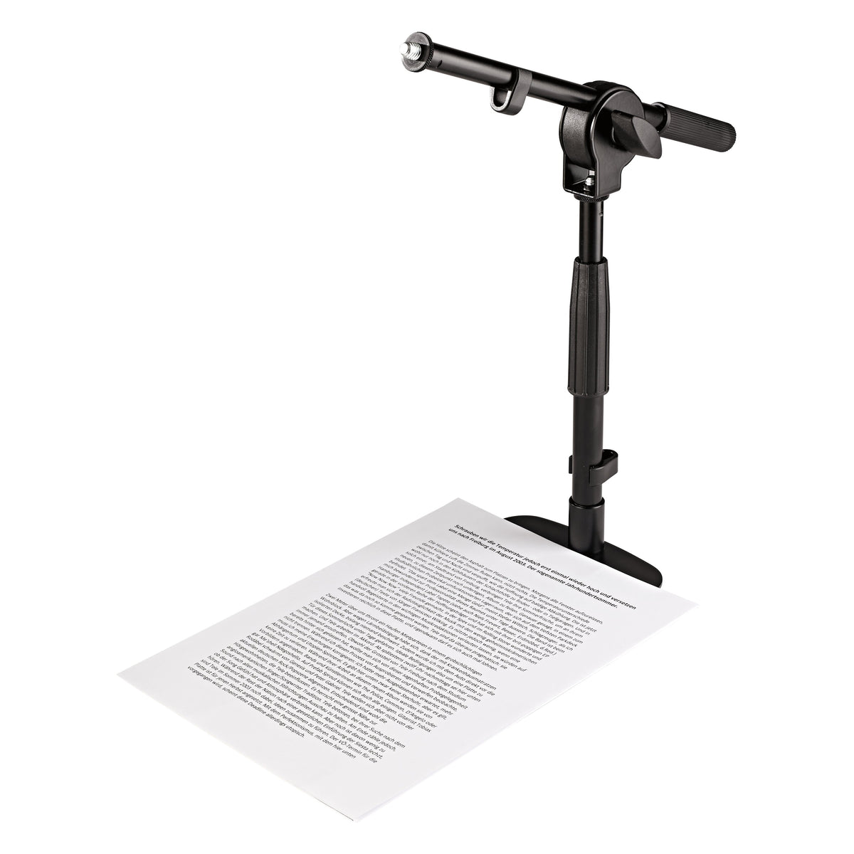 25995 table and floor microphone stand in use with the compact base sitting on an A4 sheet of paper to show its small footprint, K&M