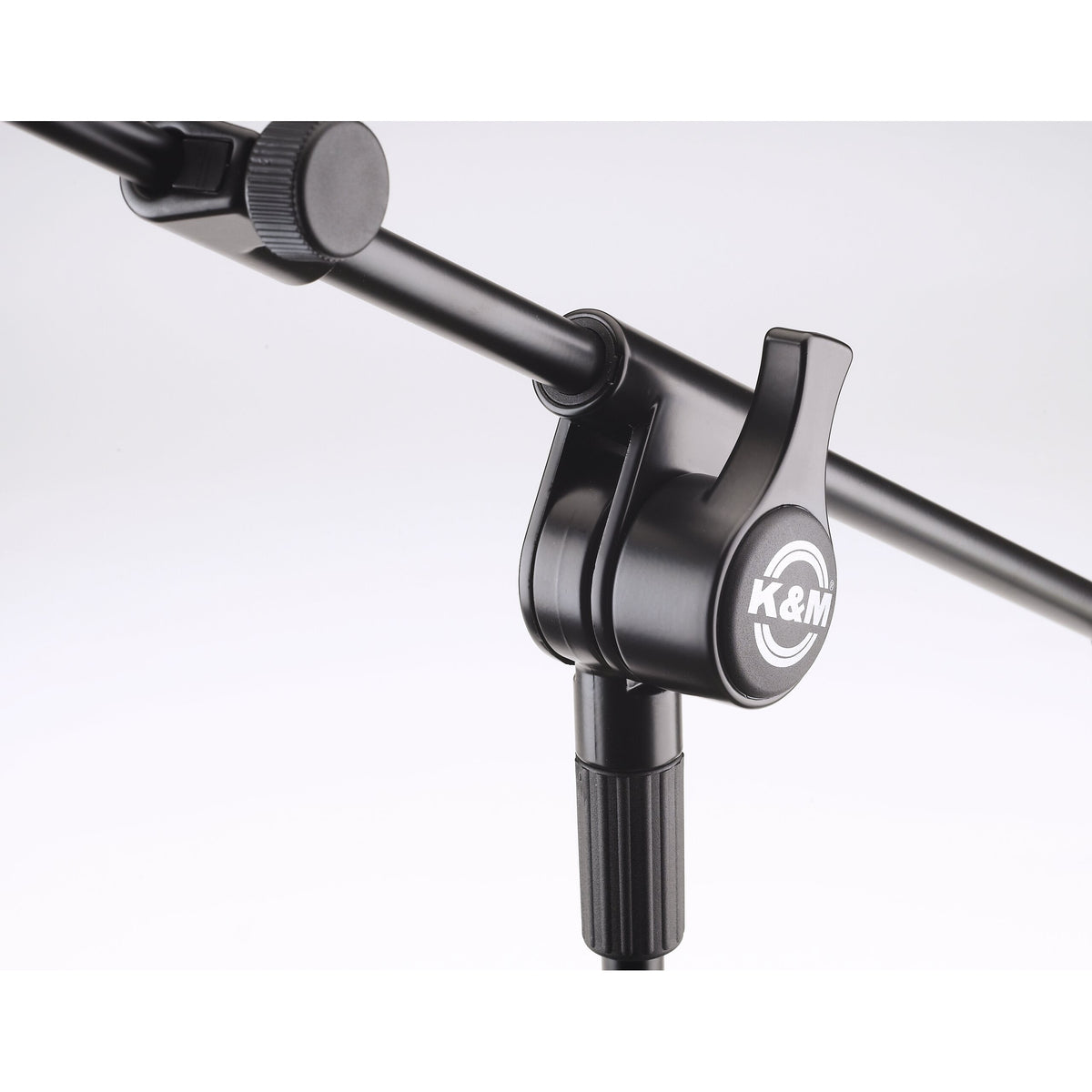 25600 boom arm pivot joint close-up showing K&M logo clamp lever and boom extension locking knob, K&M