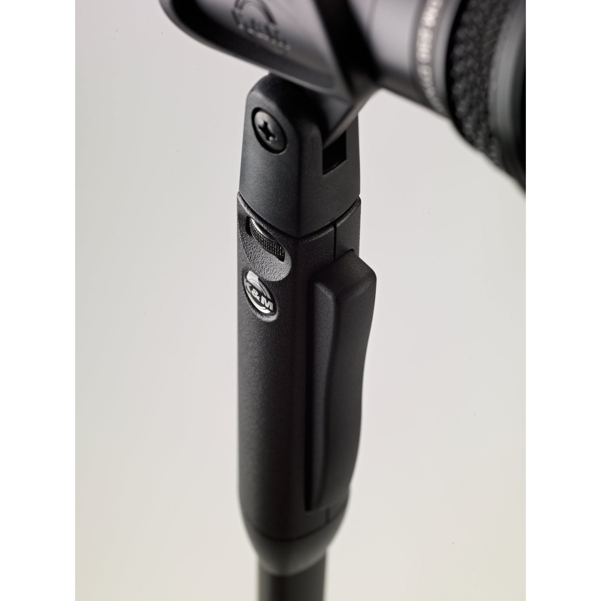 26200 Elegance One-Hand mic stand close-up of grip housing showing release lever, K&M badge, clip pivot screw and ribbed thumbwheel, K&M