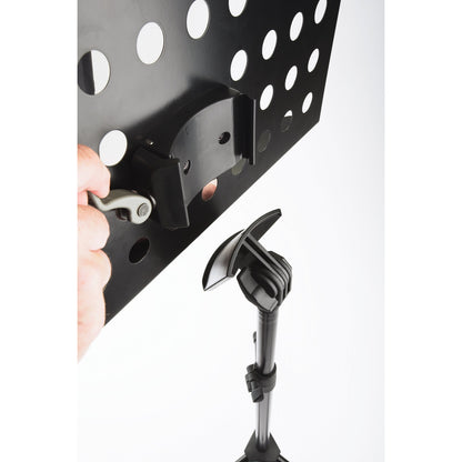 11940 orchestra music stand quick-release lock detail with hand operating grey lever to detach perforated desk from stand head, K&M