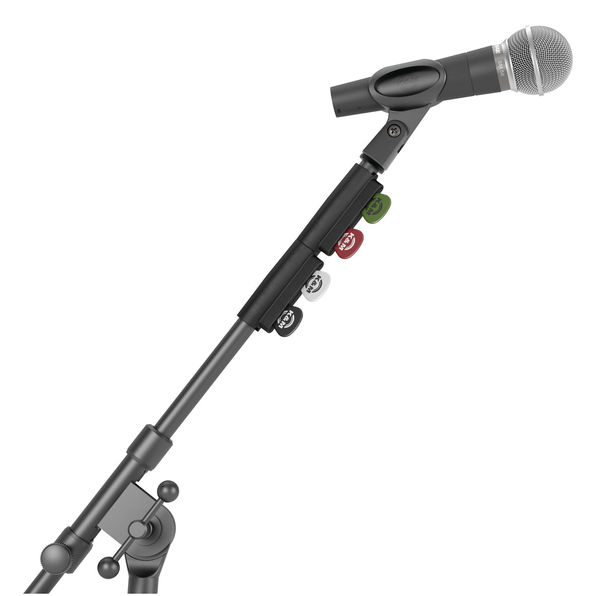 14510 pick holder in use clipped to a microphone stand boom tube below a mic clip and handheld microphone, with four coloured picks, K&M