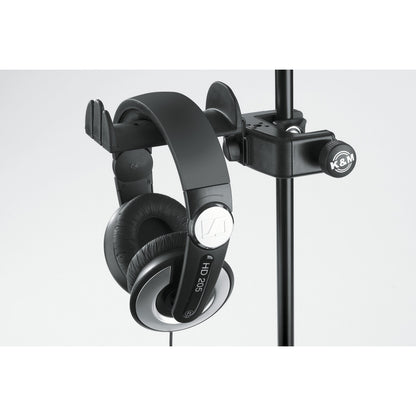 16085 headphone holder close-up mounted on a vertical mic stand tube, K&M-branded clamp knob and HD 205 headphones hanging from the cradle, K&M