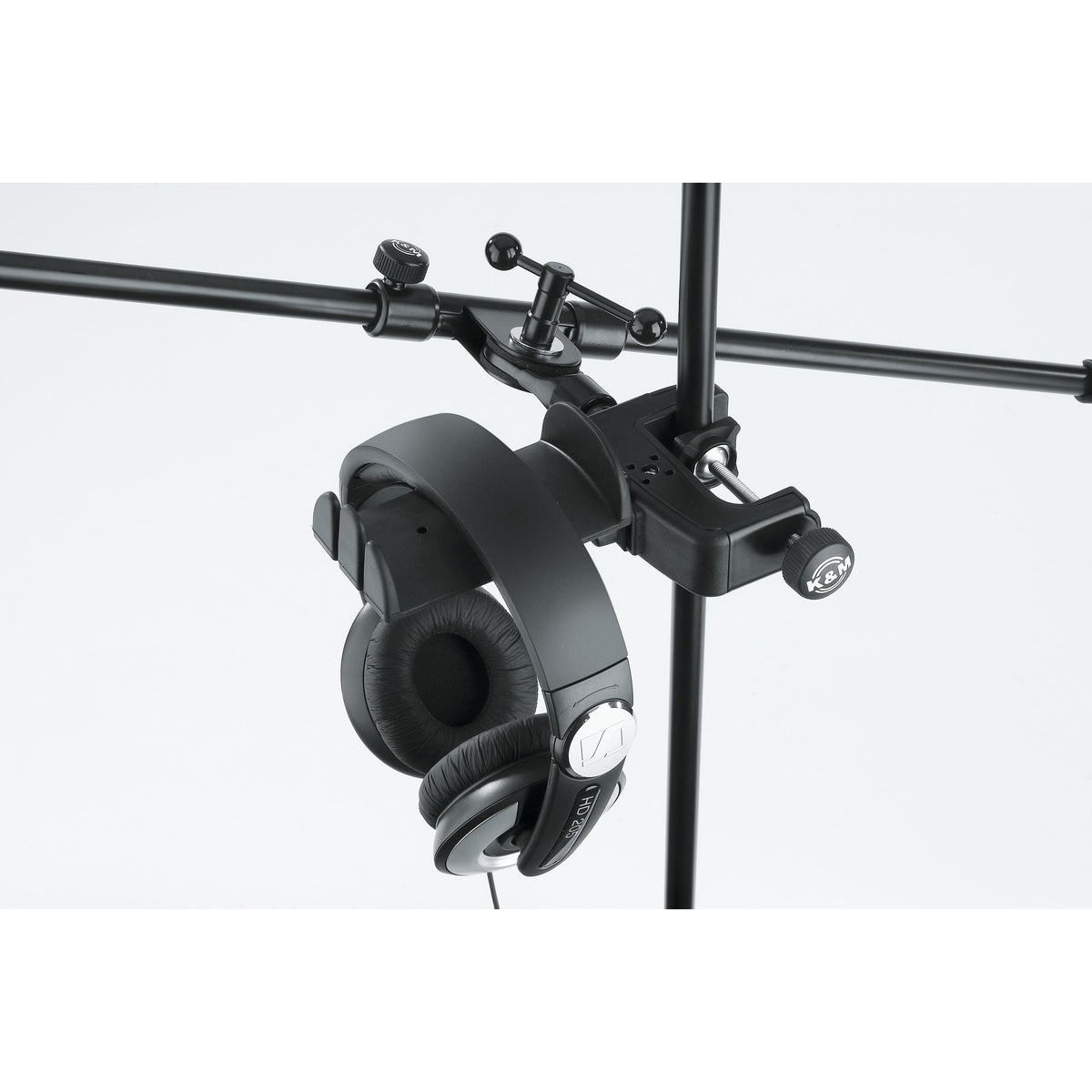 16085 headphone holder clamped to a vertical stand below a horizontal boom arm with clamp knob and headphones hanging, K&M