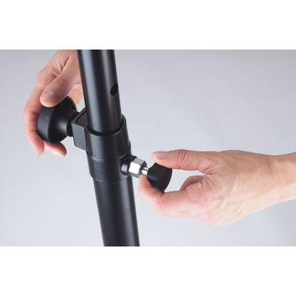 21336 distance rod clamp collar in use with hands tightening the black clamping knobs and adjustment hole visible in upper tube, K&M