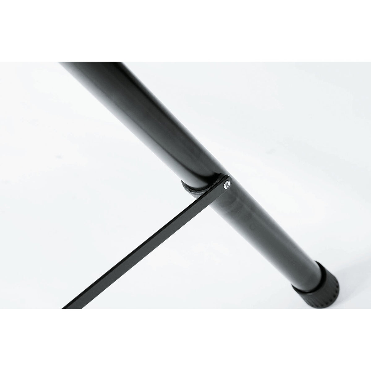 21435 speaker stand leg close-up showing riveted spreader brace bar fixed to the black steel leg above the rubber foot, K&M