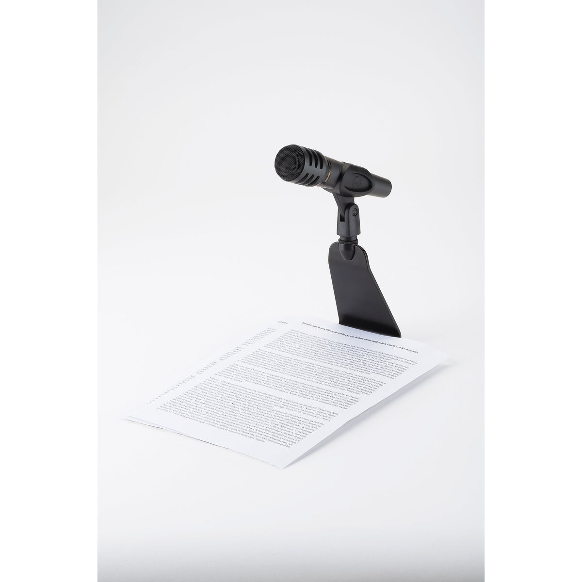 23250 flat base table microphone stand with microphone, base slid under a printed sheet of paper for reading at a desk, K&M