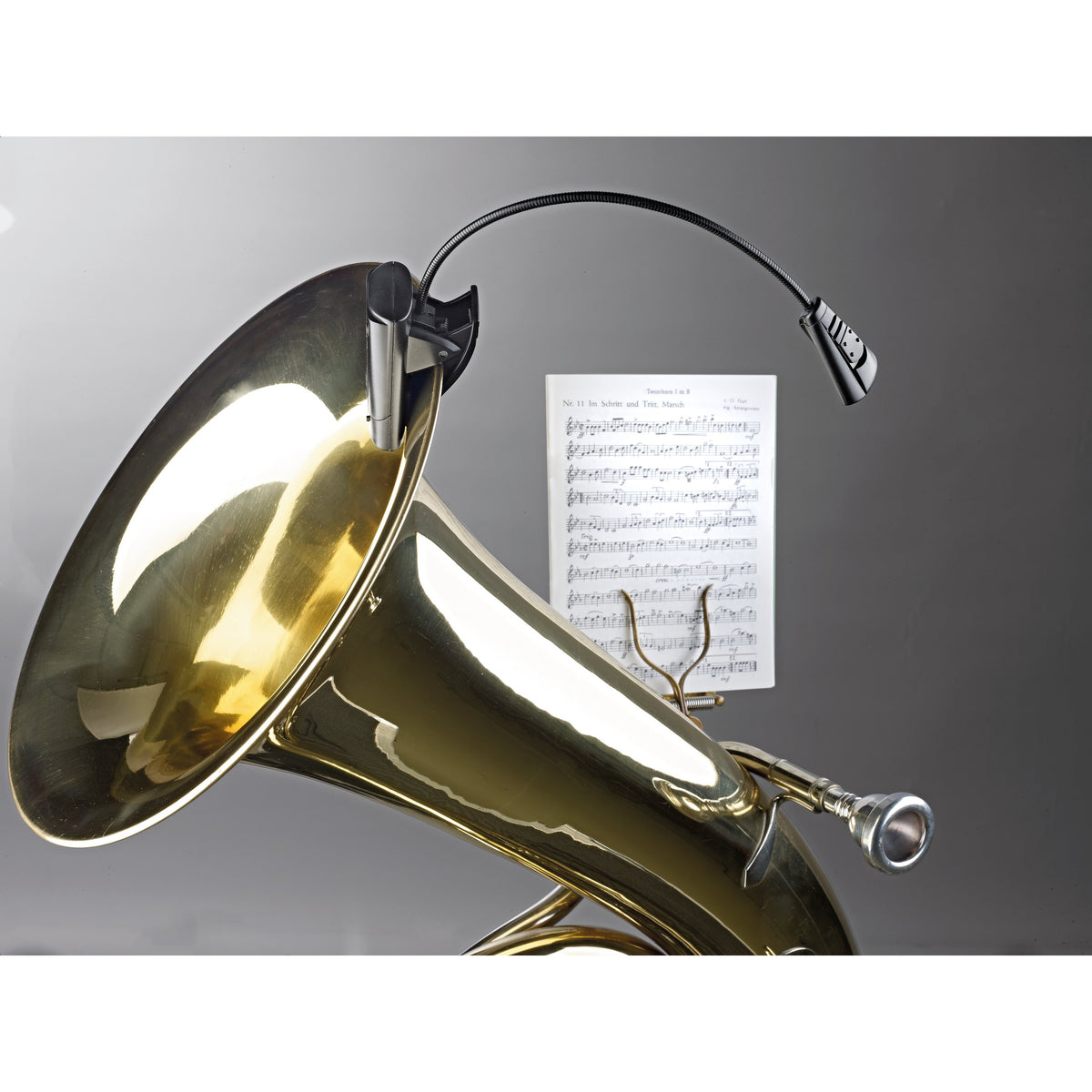 12241 LED FlexLight in use clipped to a brass tuba bell, gooseneck arched over sheet music, K&M