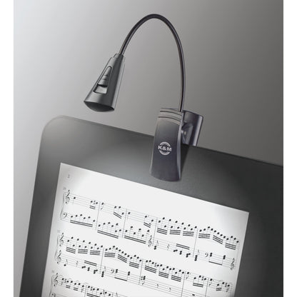 12242 LED flex light in use clipped to a music stand desk with the lamp head and slide switch illuminating sheet music, K&M