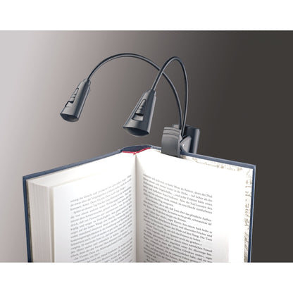 12244 dual-head LED FlexLight clipped to the cover of an open book, showing lamp head slide switches and goosenecks, K&M