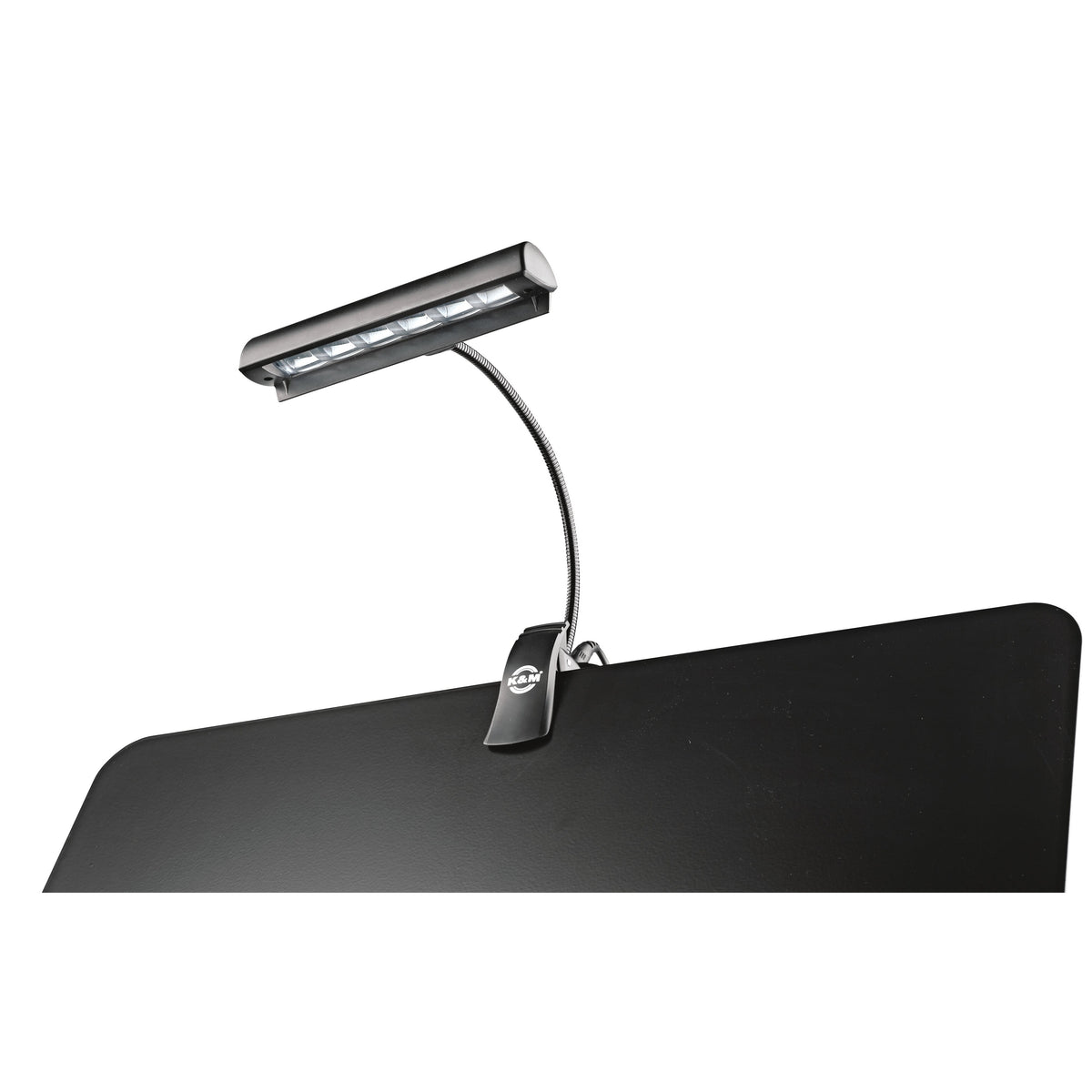 12248 Concert Orchestra music stand light clipped to the edge of a black music stand desk with LED strip switched on, K&M