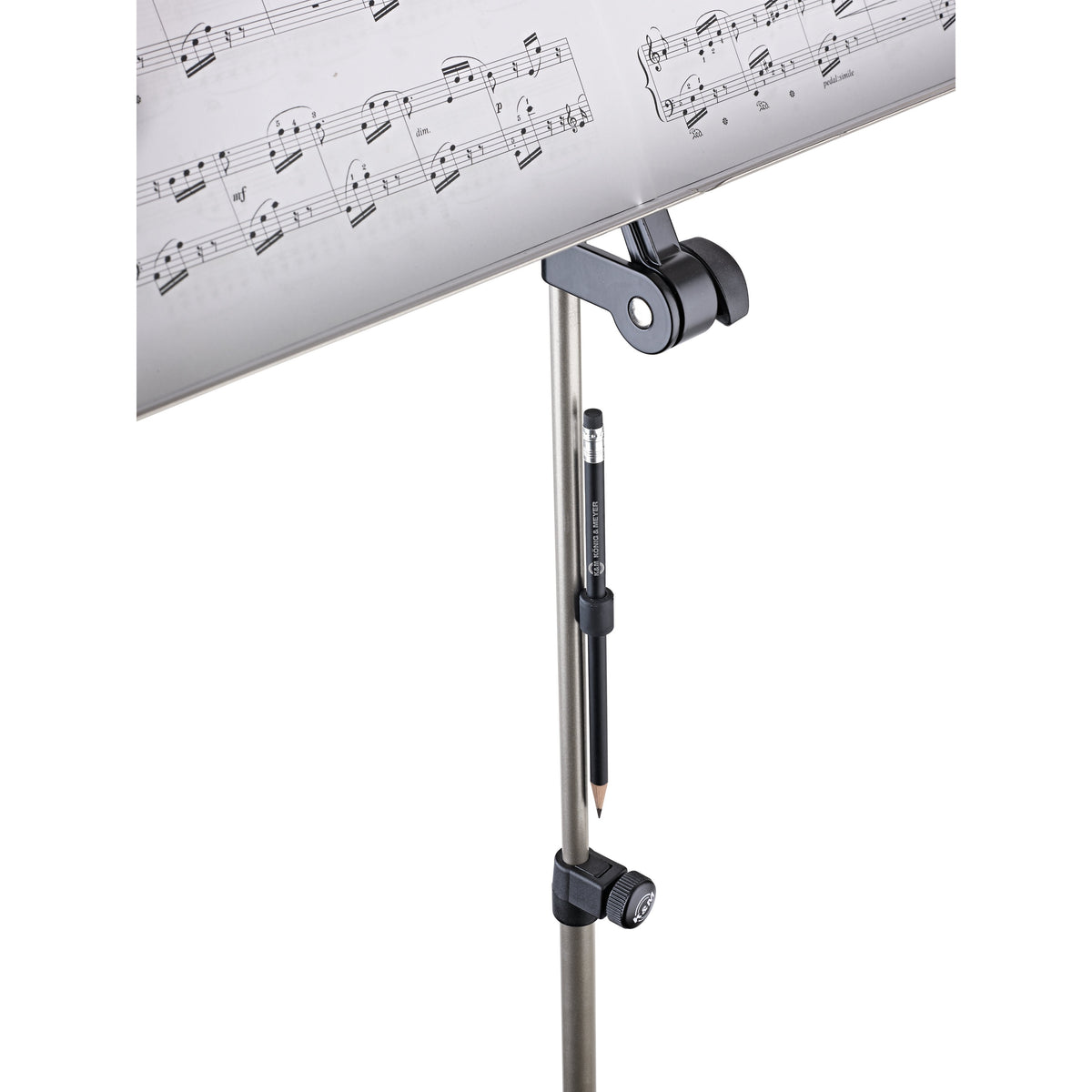 16099 magnetic pencil holder in use, clinging to the tube of a music stand below the sheet music desk with pencil held vertically, K&M
