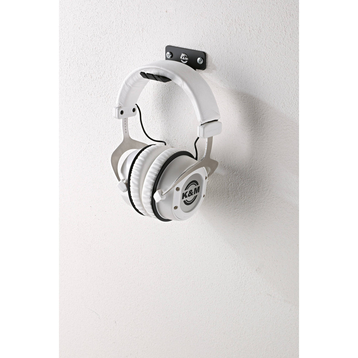 KM 16311.000.55 wall bracket mounted with two screws supporting white studio headphones by the headband, K&M