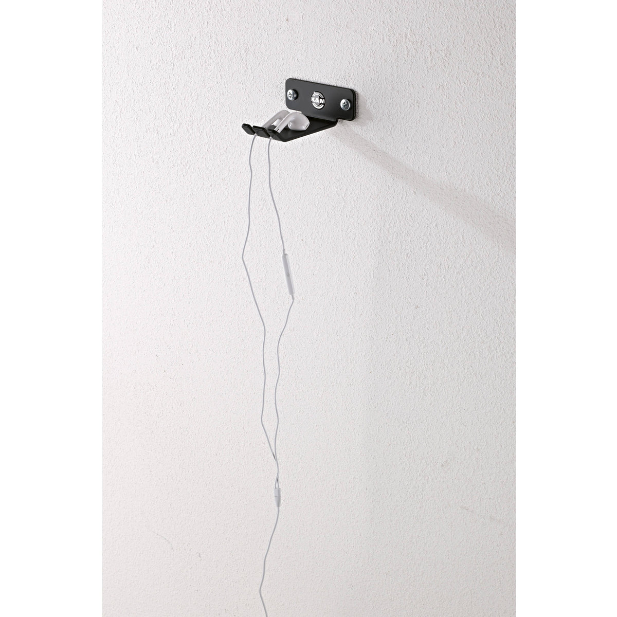 KM 16311.000.55 low-profile headphone holder mounted on wall holding white earbuds, showing compact footprint, K&M