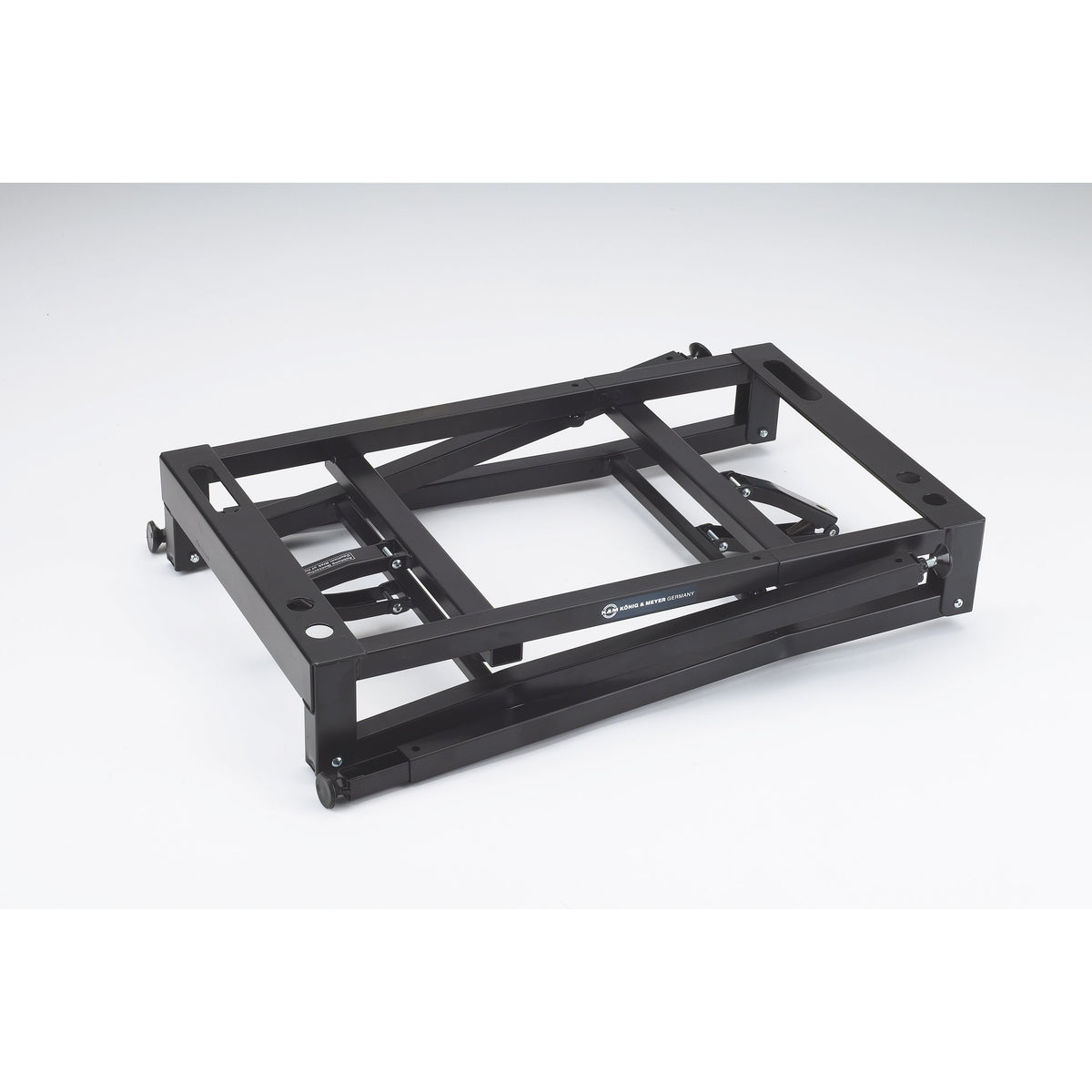 18950 table-style keyboard stand folded flat showing collapsed frame and König & Meyer Germany logo on the cross rail, K&M