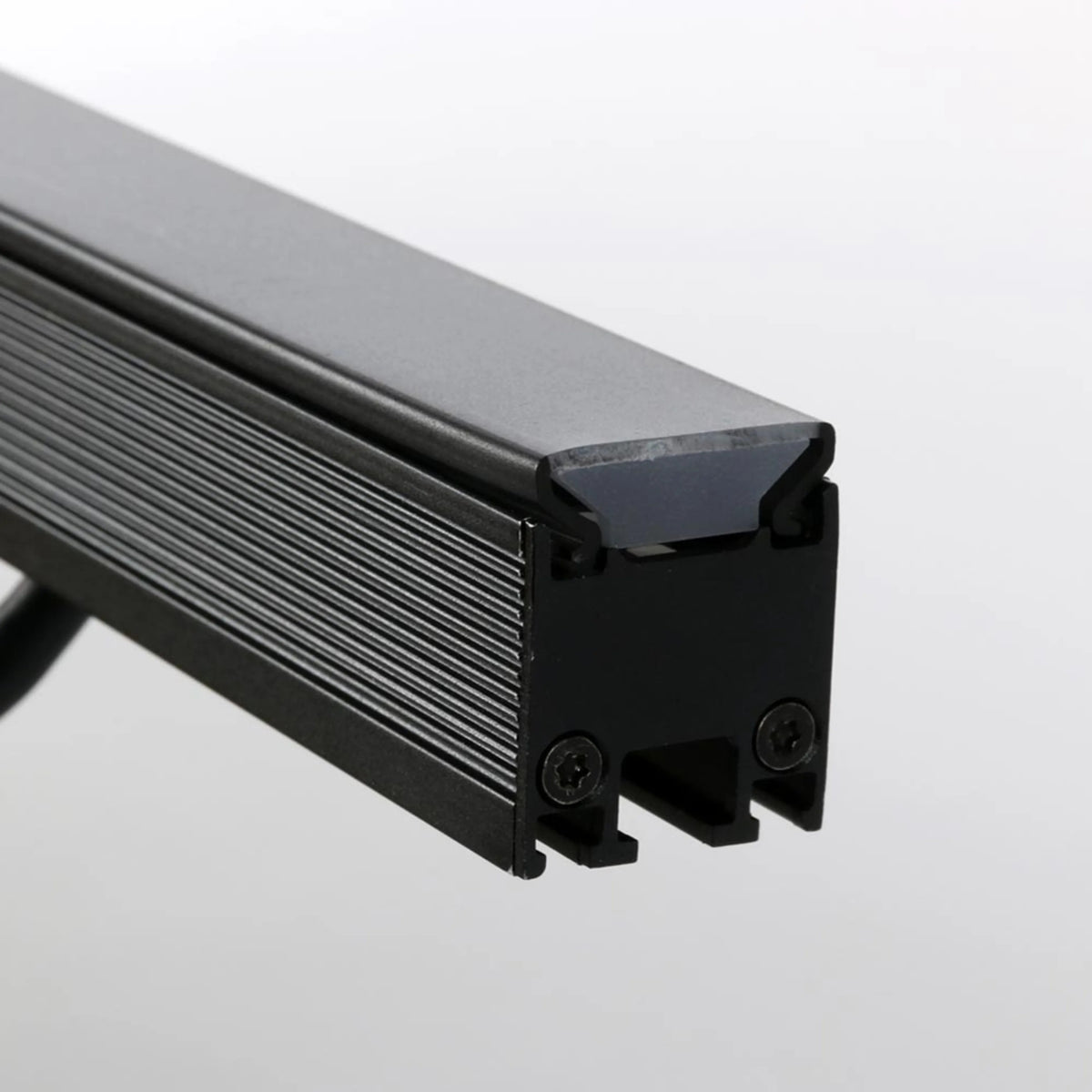 VDO Sceptron 320mm flat smoked diffuser end detail showing smoked lens seated in black finned extrusion with end-cap screws, Martin Lighting