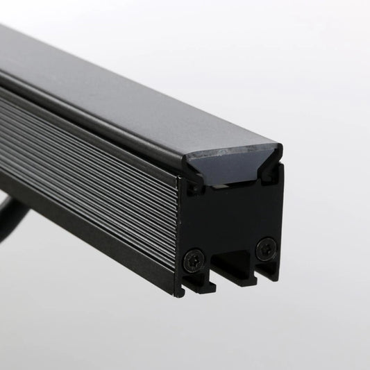 VDO Sceptron 1000mm flat smoked diffuser end detail showing smoked lens seated in finned black extrusion with screw-fixed end cap, Martin Lighting